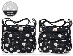 Close-up of black nylon shoulder bag with white sunflower prints and zipper pockets