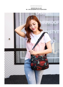 Close-up of floral nylon crossbody bag with multiple zippers and adjustable strap