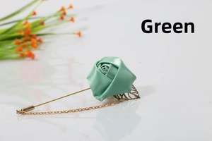Detail of green handmade fabric rose brooch with gold leaves and hanging chain accessory