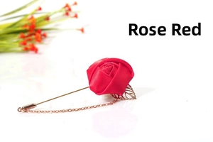 Detail of rose red fabric flower brooch with gold chain and leaf on long pin