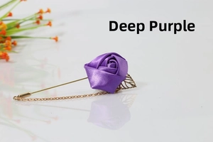 Detail of dark purple satin rose brooch with gold chain and hollow leaf accessory