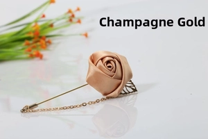 Macro detail of Champagne Gold rose brooch with satin texture and metal leaf chain