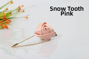 Detail of an ivory pink satin rose brooch with a long gold needle and fine chain