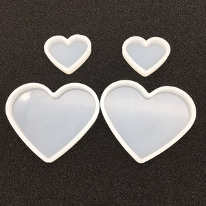 Top view of four translucent heart-shaped silicone molds for DIY resin and soap crafts