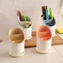 Kitchen cutlery organizer detail showing beige, green, blue, and pink plastic chopstick holders