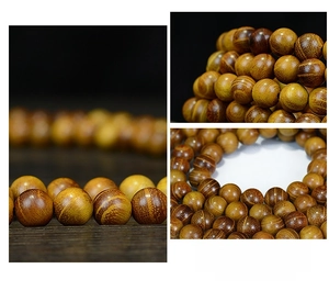 Macro de 108 perles de prière en santal poli révélant le grain naturel du bois