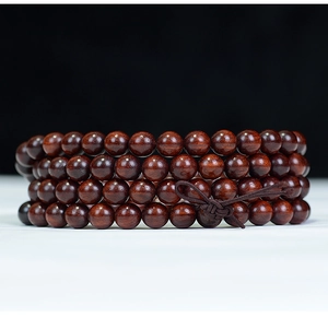 Detailed view of dark brown sandalwood prayer beads with traditional knot and smooth finish