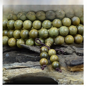 Gros plan de perles bouddhistes en bois de santal vert avec grain naturel sur vieux bois