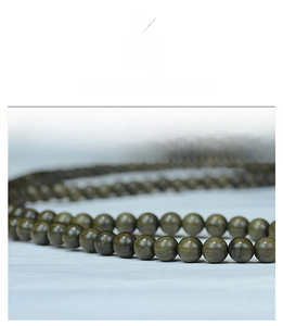 Macro detail of 108 wooden prayer beads showing natural dark green grain textures