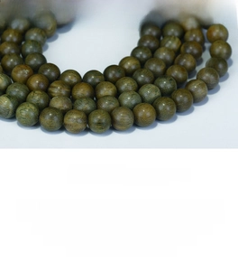 Gros plan de 108 perles en bois de santal vert montrant le grain fin et le lustre doux