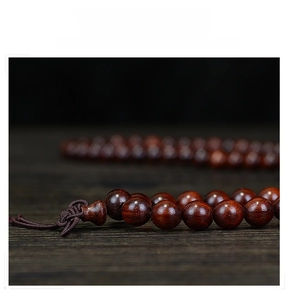 Macro shot of polished red sandalwood beads showing fine wood grain and texture