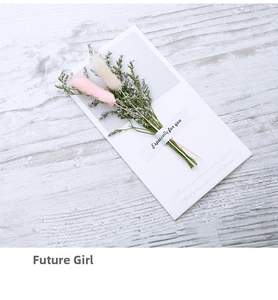 Detail of handmade greeting card with pink dried rabbit tail grass on wooden background