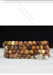 Macro shot of 108 multi-color natural wooden beads with carved silver Buddha head pendant