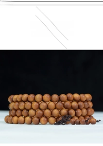 Macro detail of 108 sandalwood prayer beads with traditional dark brown Chinese knot
