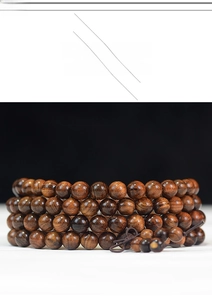 Macro detail of 108 dark rosewood prayer beads showing natural grain and wood texture