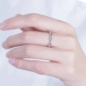 Silver twisted band couple ring featuring sparkling stones on a model's finger