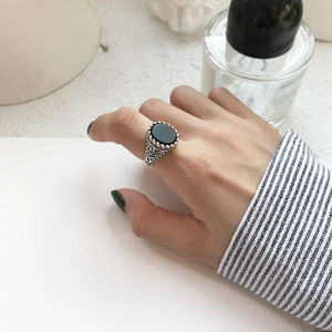 Macro detail of vintage S925 silver ring featuring black onyx with ornate filigree patterns