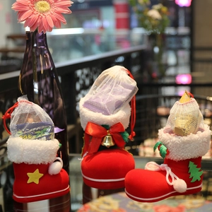 Three red flocked Christmas boot ornaments with plush white trim and drawstring mesh bags