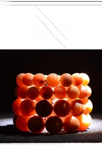 Close-up of translucent blood dragon wood beads glowing red under strong light focus