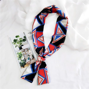 Macro shot of narrow silk scarf with geometric red and blue patterns on white fabric