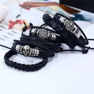 Close-up of four-piece braided leather bracelets with skull and star metal charms