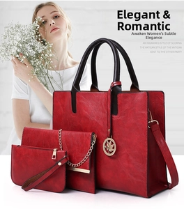 Detailed macro view of three-piece red faux leather handbag set with maple leaf charm