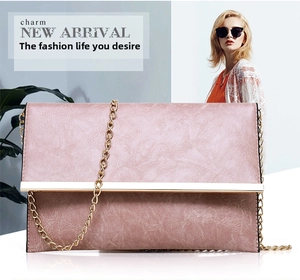 Detail of dusty pink PU leather crossbody bag featuring gold metal bar and chain strap