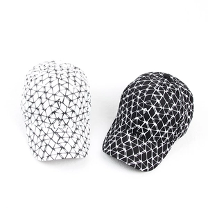 Detail view of cotton baseball caps with modern geometric triangular patterns in black and white