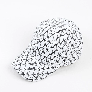 Detail view of a baseball cap featuring a black and white geometric triangle grid pattern