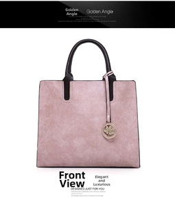 Front view of mauve PU leather tote bag with brown handles and golden maple leaf charm