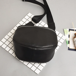 Minimalist black PU leather crescent chest bag with adjustable wide strap and silver zipper