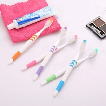Detail view of five colorful manual toothbrushes with non-slip grips and travel accessories