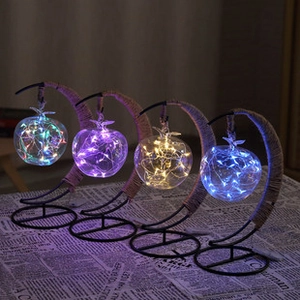 Detail of crescent moon lamps with apple shaped glass and LED copper wire fairy lights