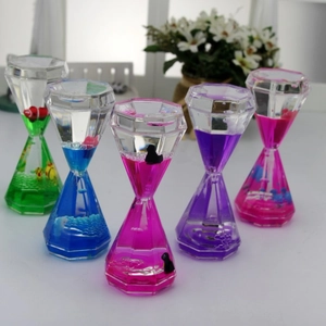 Row of colorful liquid diamond sandglass timers with animal figures on a home desk