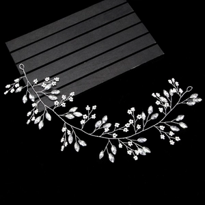 Macro detail of bridal hair vine featuring rhinestones, pearls and silver wire craftsmanship