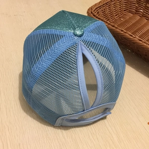 Dettaglio del foro per la coda di cavallo sul cappellino blu con paillettes e rete