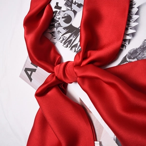Elegant solid red silk scarf for women featuring a smooth glossy finish and knotted design
