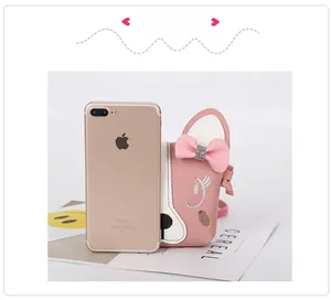 Pink cartoon puppy crossbody bag size comparison with a smartphone on white background