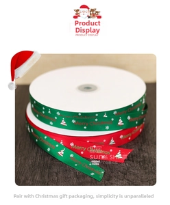Detail of red and green Merry Christmas satin ribbons with snowflakes on dark wood background