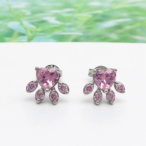 Macro view of pink zircon cat paw stud earrings with silver heart-shaped stone detail