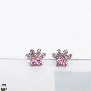 Macro detail of cat paw stud earrings with pink heart stones and silver metal
