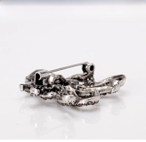 Macro view of vintage silver octopus brooch back showing pin clasp and retro texture