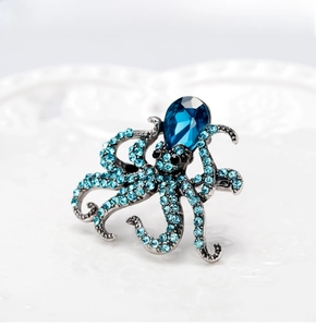 Detailed view of octopus brooch with gradient blue rhinestones and teardrop gemstone