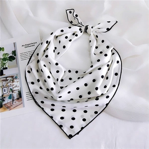 Close-up of polka dot silk scarf with black contrast stitching and retro French style