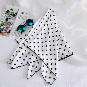 Chic black and white polka dot silk scarf styled with sunglasses on a fashion magazine