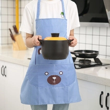 Detailed view of a blue striped apron featuring a cute cartoon bear and front storage pocket