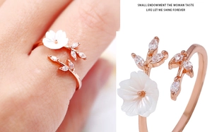 Detail of rose gold flower ring featuring mother-of-pearl petals and sparkling zircon leaf