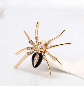 Macro shot of spider brooch with gold alloy legs, clear crystals and black enamel body