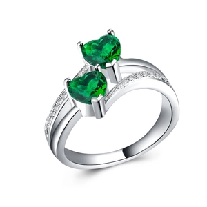 Close-up of double heart-shaped green zircon ring with silver-plated micro-paved band