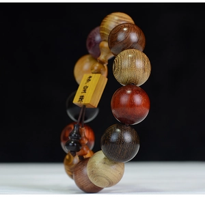 Macro shot of multi-colored sandalwood prayer beads with an engraved wooden tag